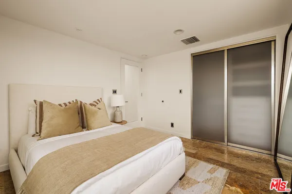 a bedroom with a bed and a painting on the wall