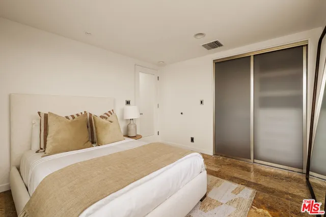 a bedroom with a bed and a painting on the wall