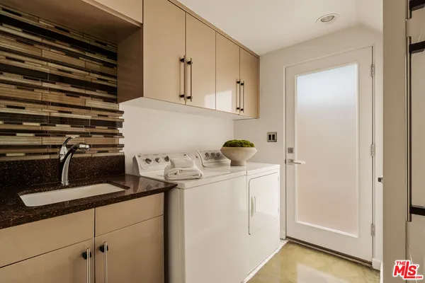 a kitchen with a refrigerator and white cabinets