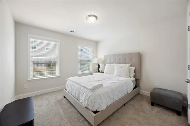 a bedroom with a bed lamp and a window