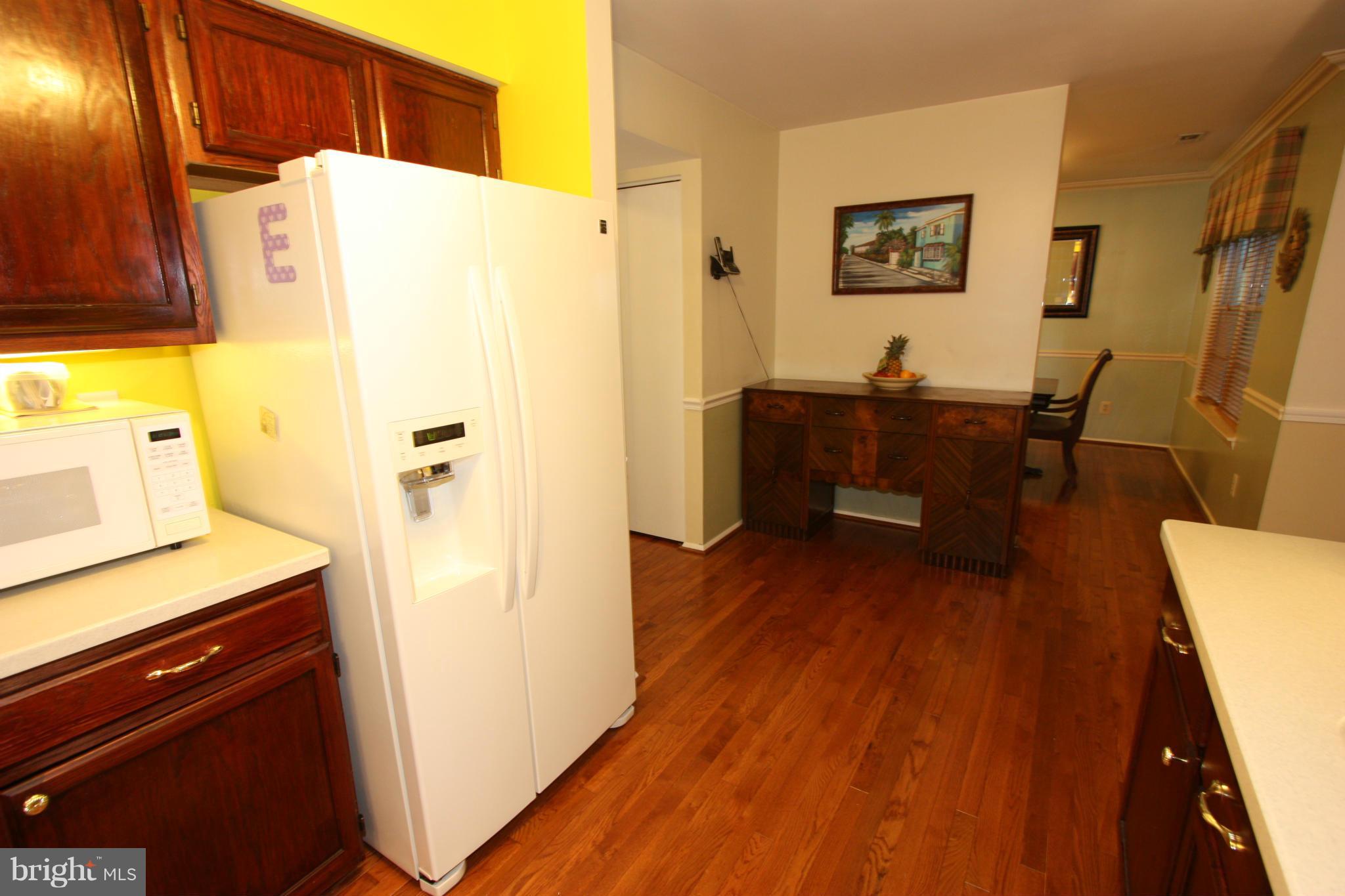 8644 Heathermill Road Nottingham, MD 21236 - Photo 6 of 30 CHERRY-STAINED WOOD CABINETS AND WOOD FLOORING