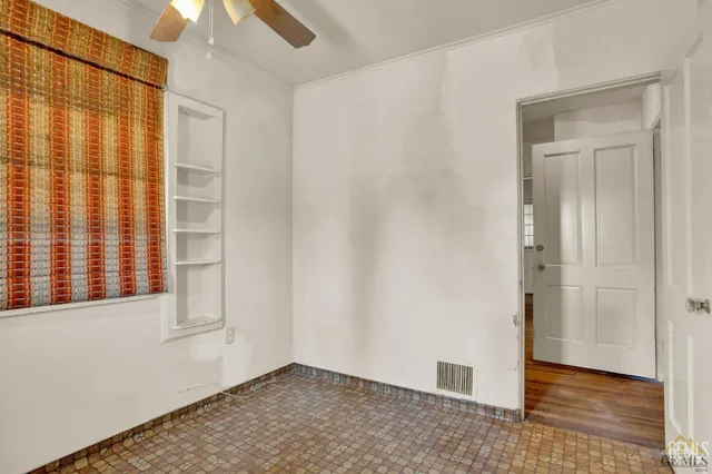 a view of a livingroom with wooden floor and a ceiling fan