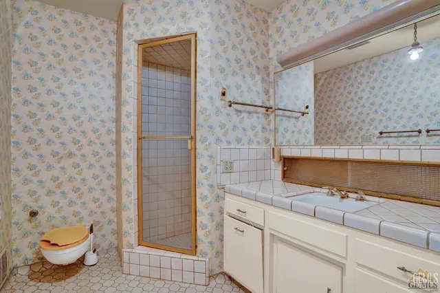 a view of a hallway with wooden floor and a bathroom