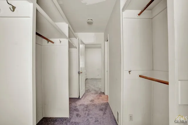 a view of an empty room with closet and stairs
