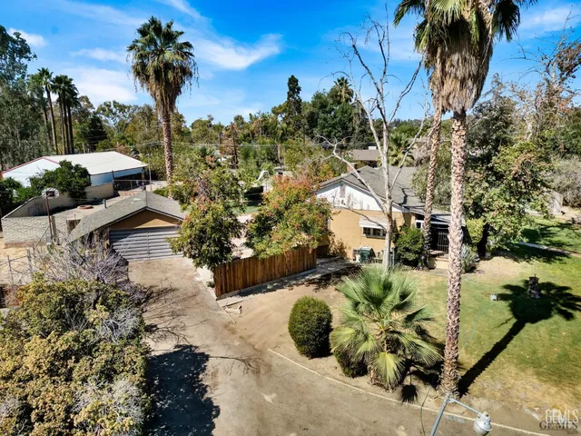 an aerial view of residential houses with outdoor space and trees
