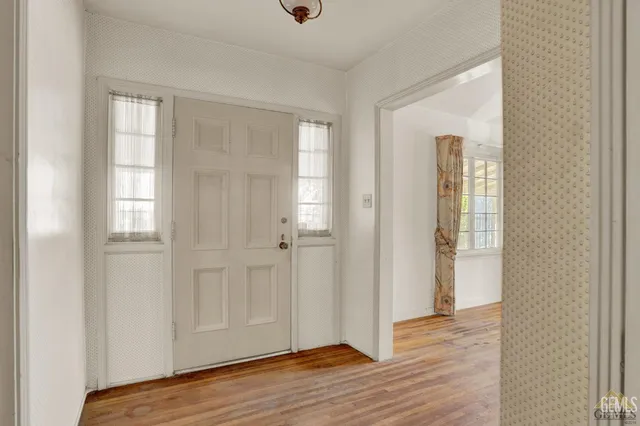 an empty room with windows and fireplace