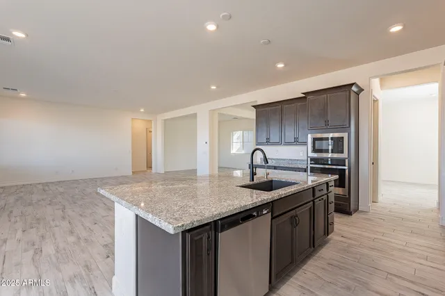 a kitchen with kitchen island granite countertop a sink stove and refrigerator