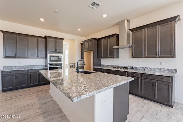 a kitchen with granite countertop sink stove and granite counter top