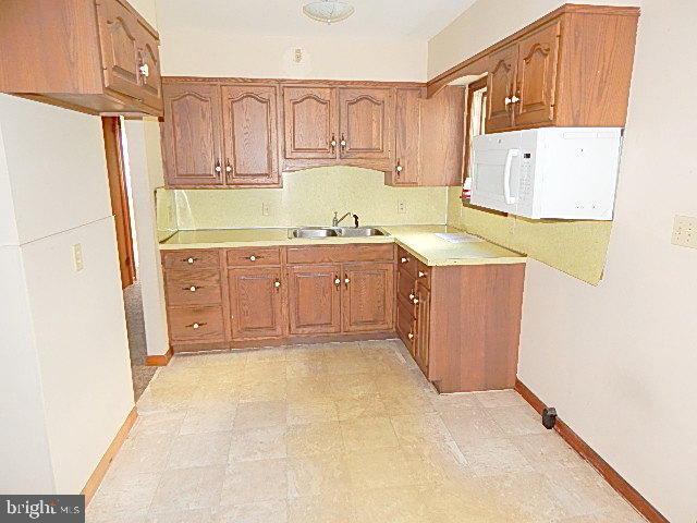 2310 Mountain Road Manheim, PA 17545 - Photo 4 of 17 a kitchen with granite countertop a sink a stove top oven a refrigerator and white cabinets