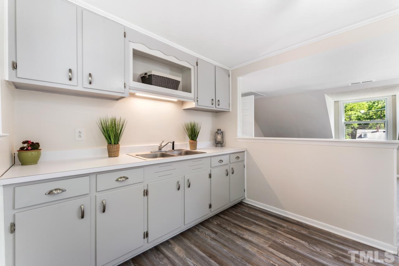 1955 Bernard Street Raleigh, NC 27608 - Photo 18 of 42 a kitchen with white cabinets and a sink