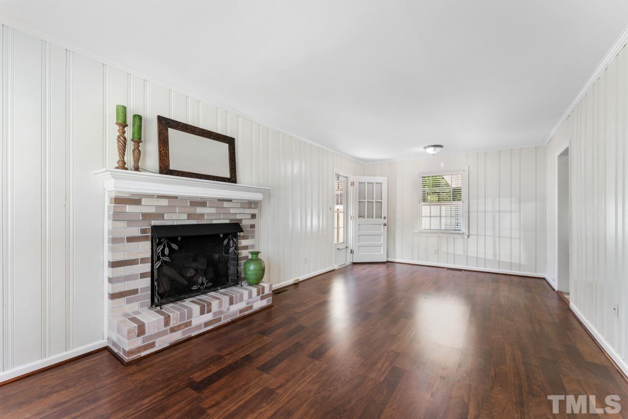 1955 Bernard Street Raleigh, NC 27608 - Photo 4 of 42 a living room with wooden floors and a fireplace