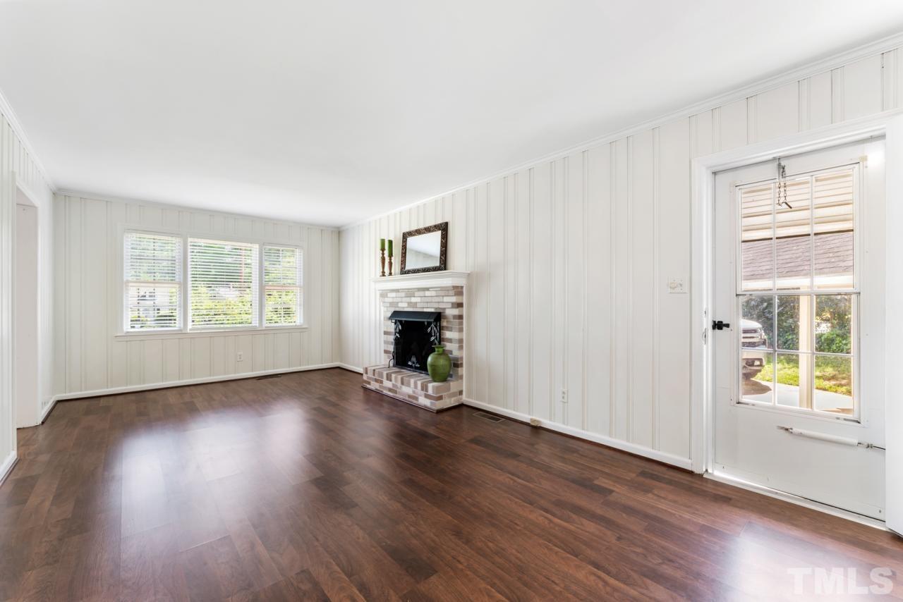 1955 Bernard Street Raleigh, NC 27608 - Photo 5 of 42 an empty room with wooden floor a ceiling fan and windows