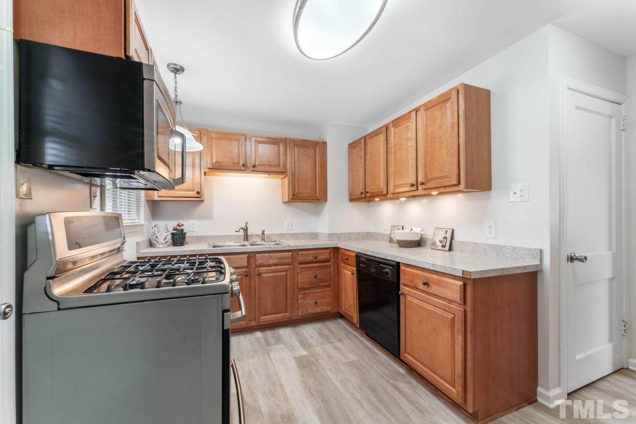 1955 Bernard Street Raleigh, NC 27608 - Photo 6 of 42 a kitchen with stainless steel appliances granite countertop a stove top oven a sink dishwasher and white cabinets with wooden floor