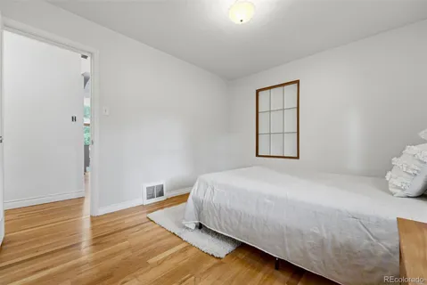 a bedroom with a bed and wooden floor