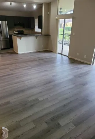 a view of a kitchen with a sink and dishwasher a microwave oven with wooden floor