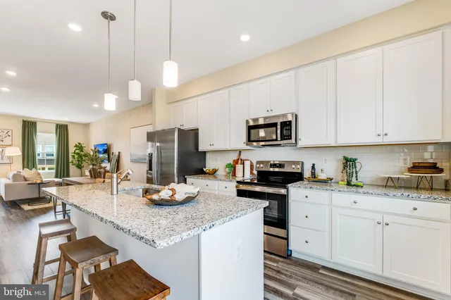 a kitchen with granite countertop a sink cabinets and stainless steel appliances