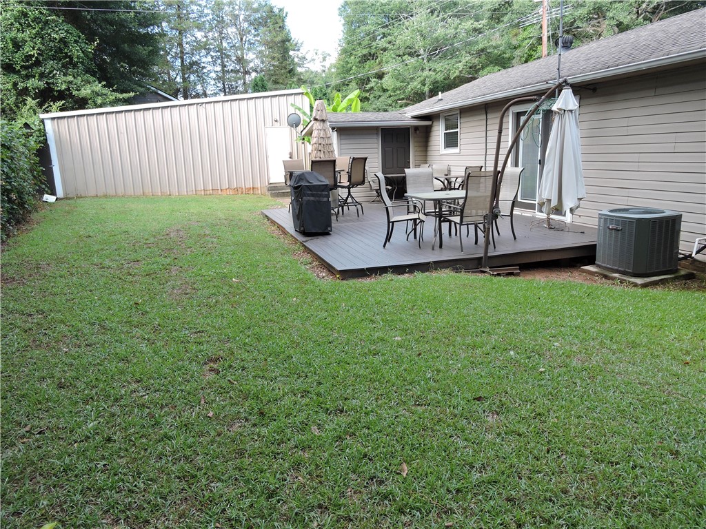 1901 Hattons Ford Road Townville, SC 29689 - Photo 23 of 33 An inviting outdoor living area with a broad deck perfect for gatherings and a well-kept grassy expanse.