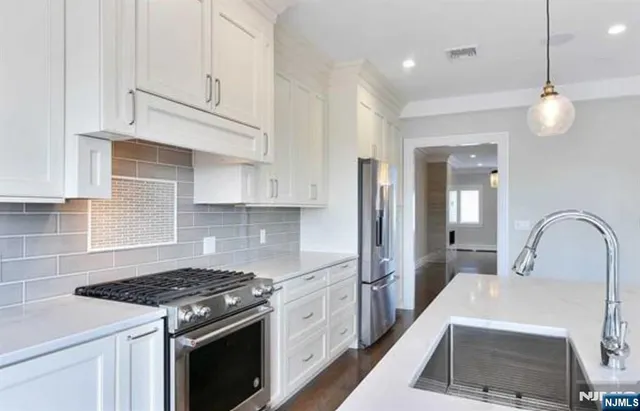 a kitchen with granite countertop a sink stainless steel appliances and cabinets