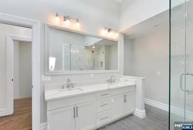 a bathroom with double sink and a mirror