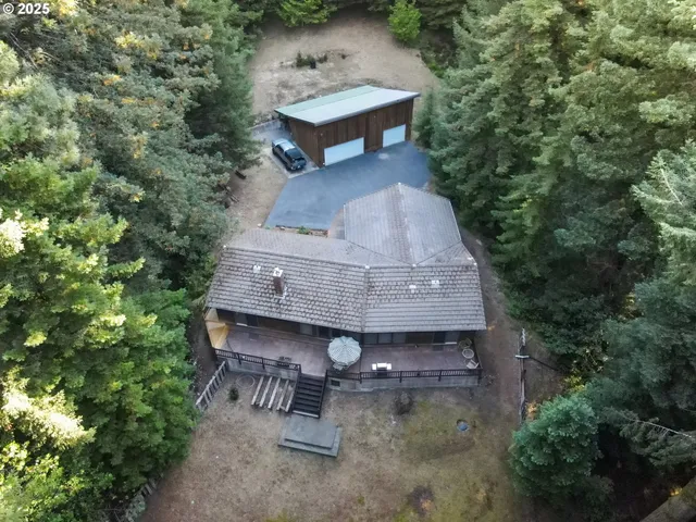 an aerial view of a house with a yard and trees
