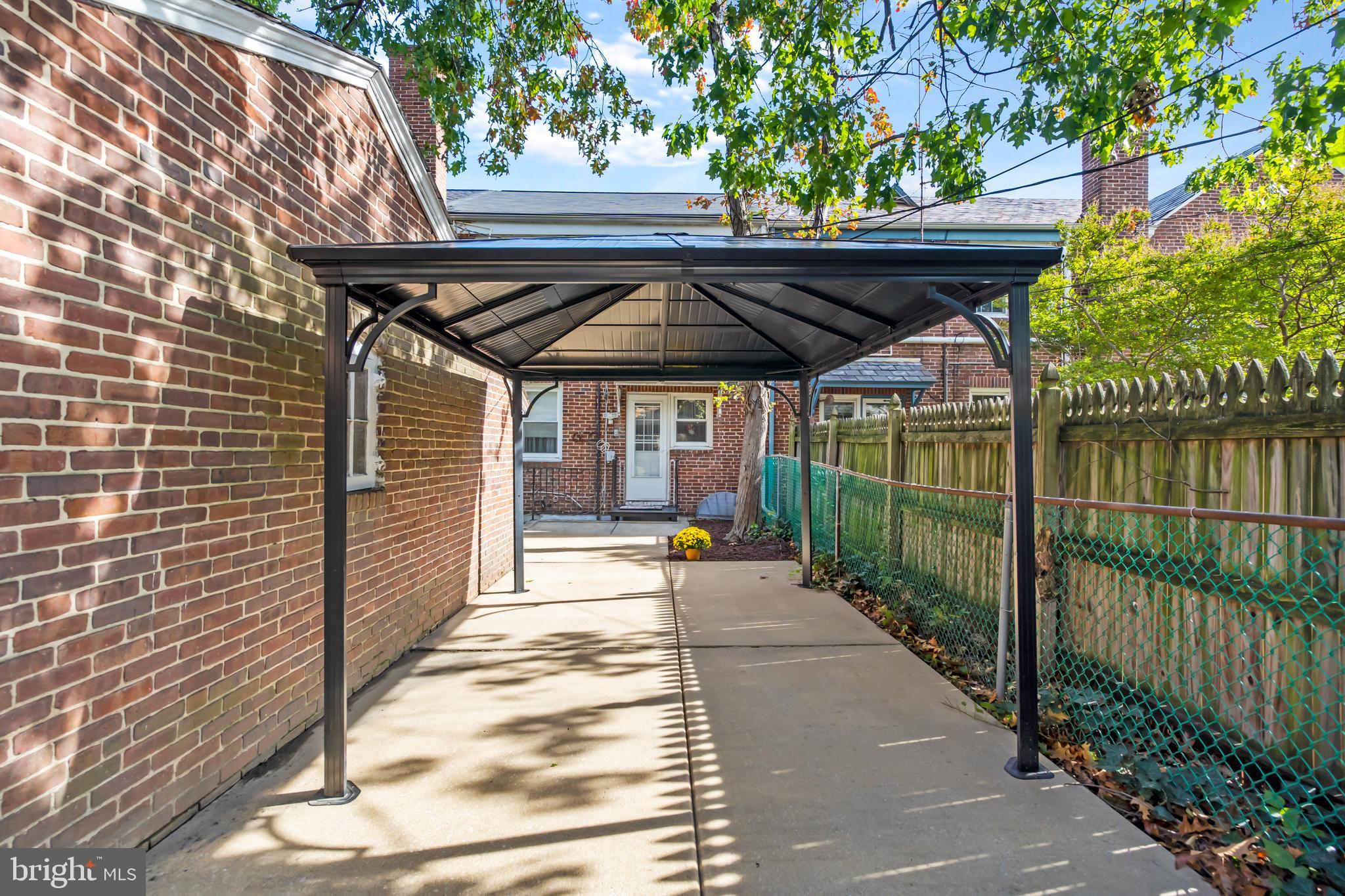 3704 Monterey Road Baltimore, MD 21218 - Photo 31 of 32 a view of a patio with a table and chairs under an umbrella with wooden fence