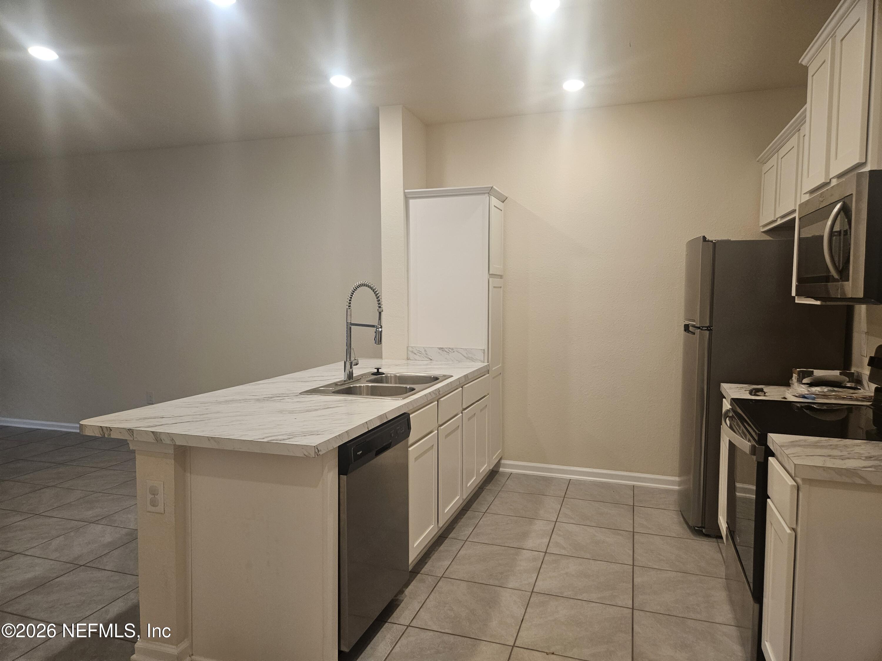86640 Shortline Circle Yulee, FL 32097 - Photo 2 of 11 a kitchen with a sink a refrigerator and a stove