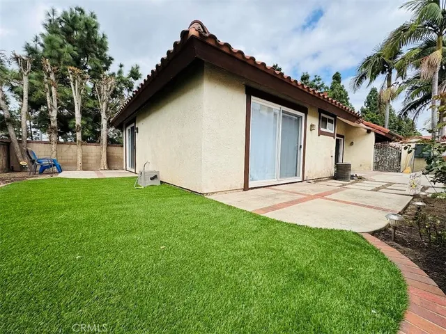 a front view of a house with a yard and trees