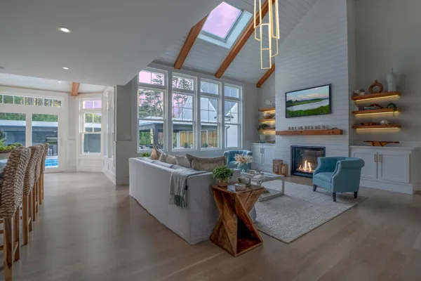 a view of a hallway with wooden floor and windows