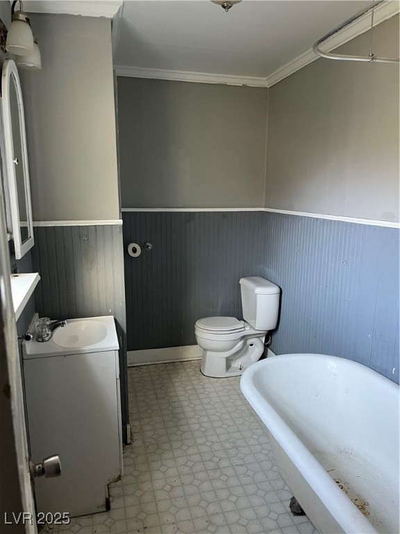 623 Murry Street Ely, NV 89301 - Photo 2 of 6 Bathroom with a freestanding tub, vanity, a wainscoted wall, light floors, and ornamental molding