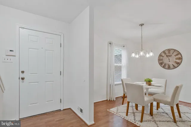 a view of a dining room with furniture a chandelier and wooden floor