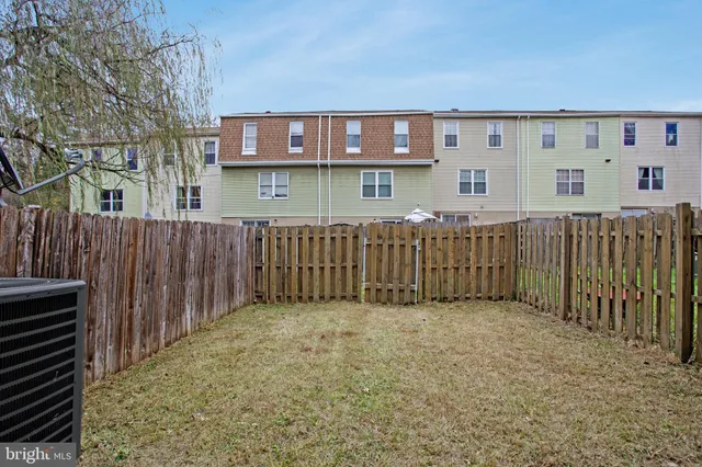 a view of a house with a backyard and a tree