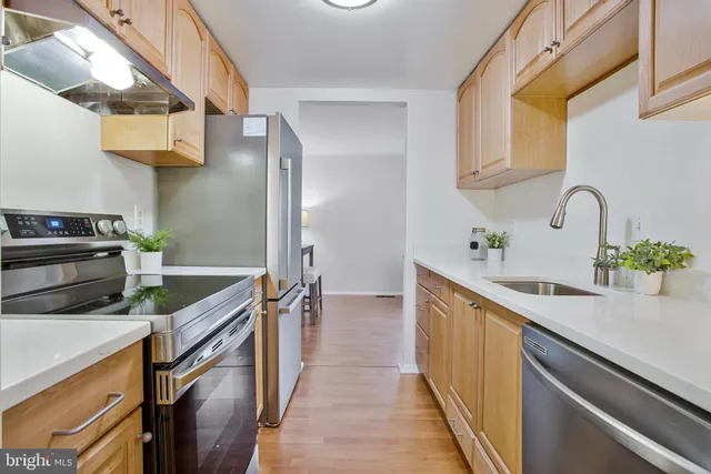a kitchen with stainless steel appliances granite countertop a sink and a stove