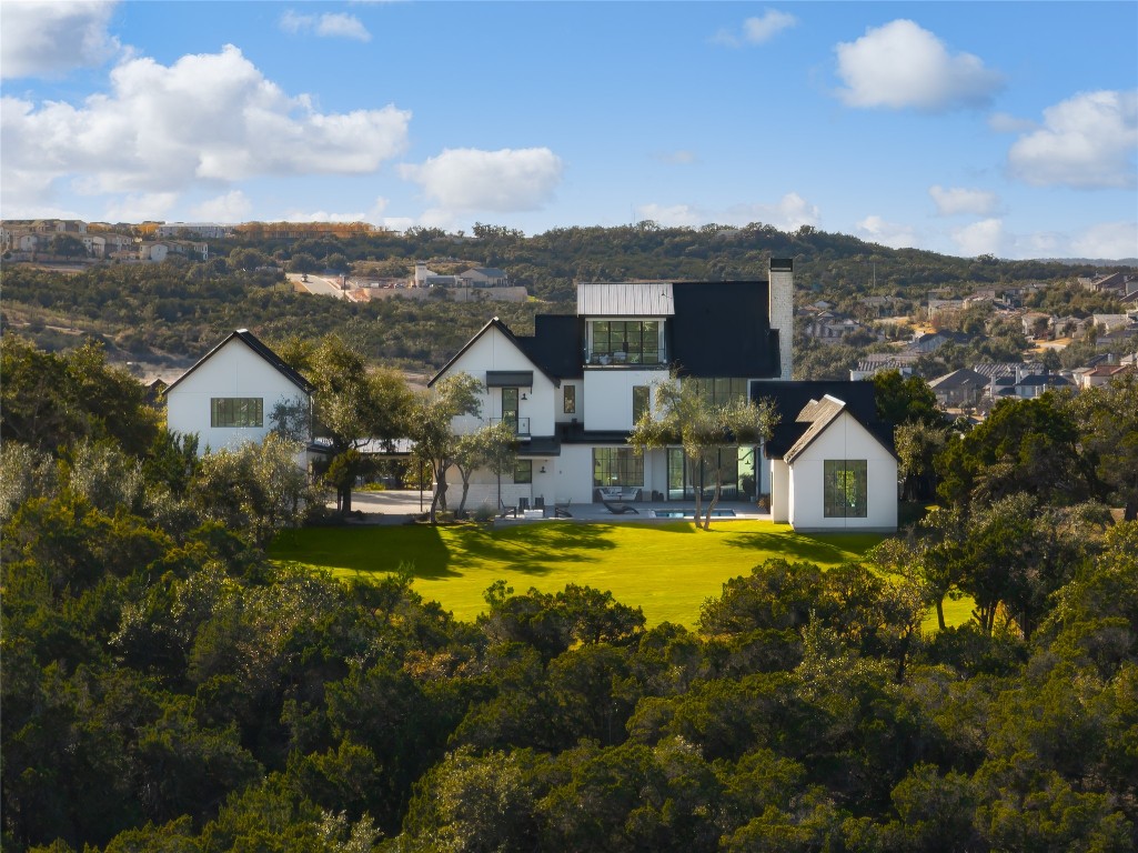 an aerial view of a house with swimming pool and mountains