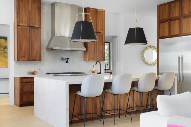 a kitchen with stainless steel appliances a dining table chairs and a refrigerator