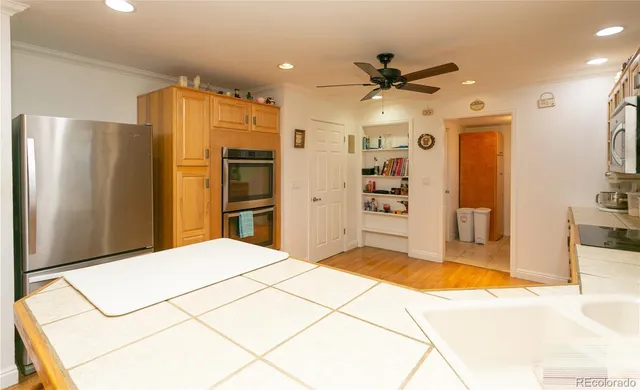 a large kitchen with stainless steel appliances a refrigerator and a stove top oven