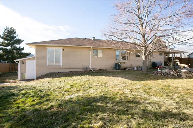 a backyard of a house with large trees and covered with wooden fence