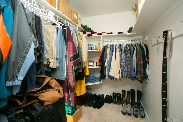 a view of walk in closet with clothes and shoes