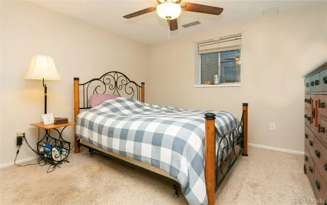 a bedroom with a bed and a lamp on the dresser