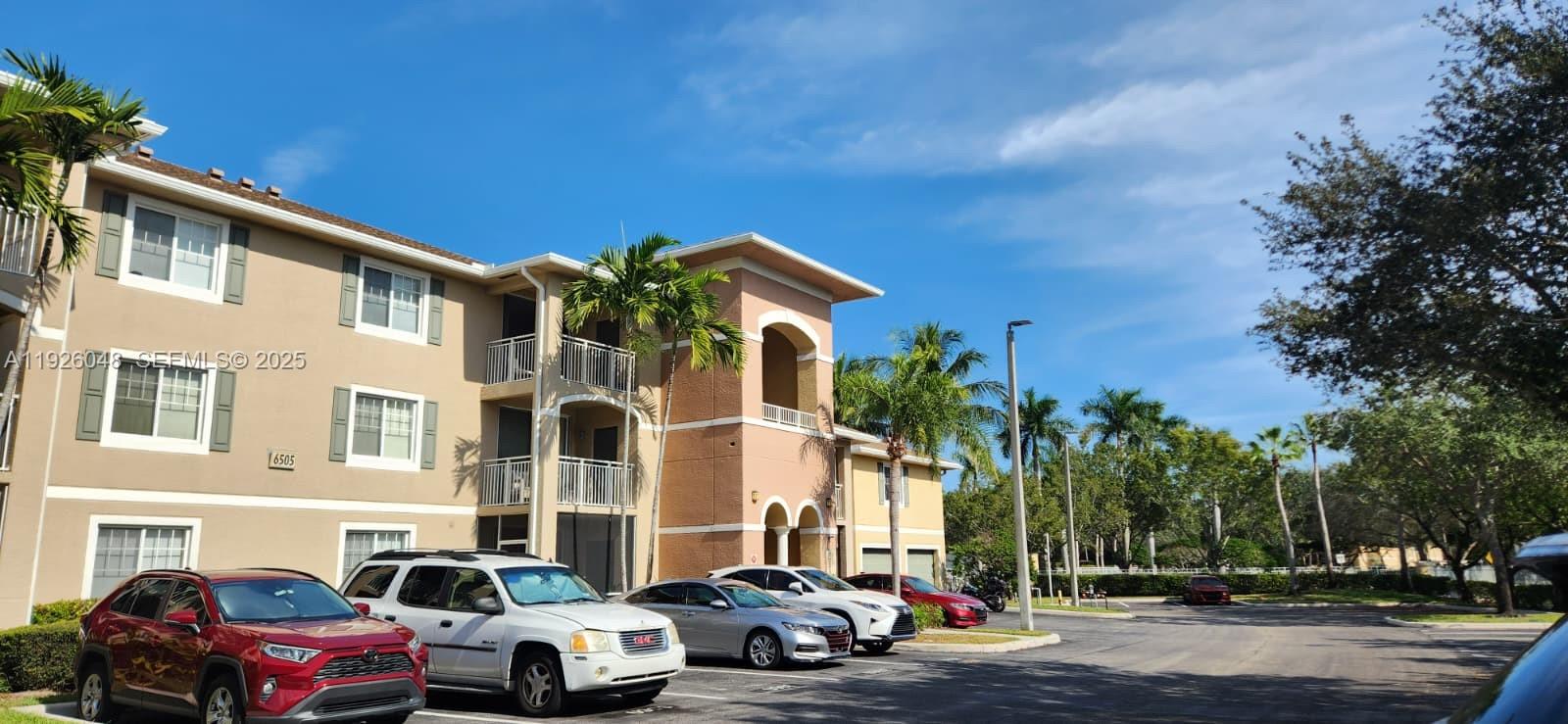 6505 Emerald Dunes Drive, Unit 307 West Palm Beach, FL 33411 - Photo 15 of 17 a couple of cars parked in front of a building