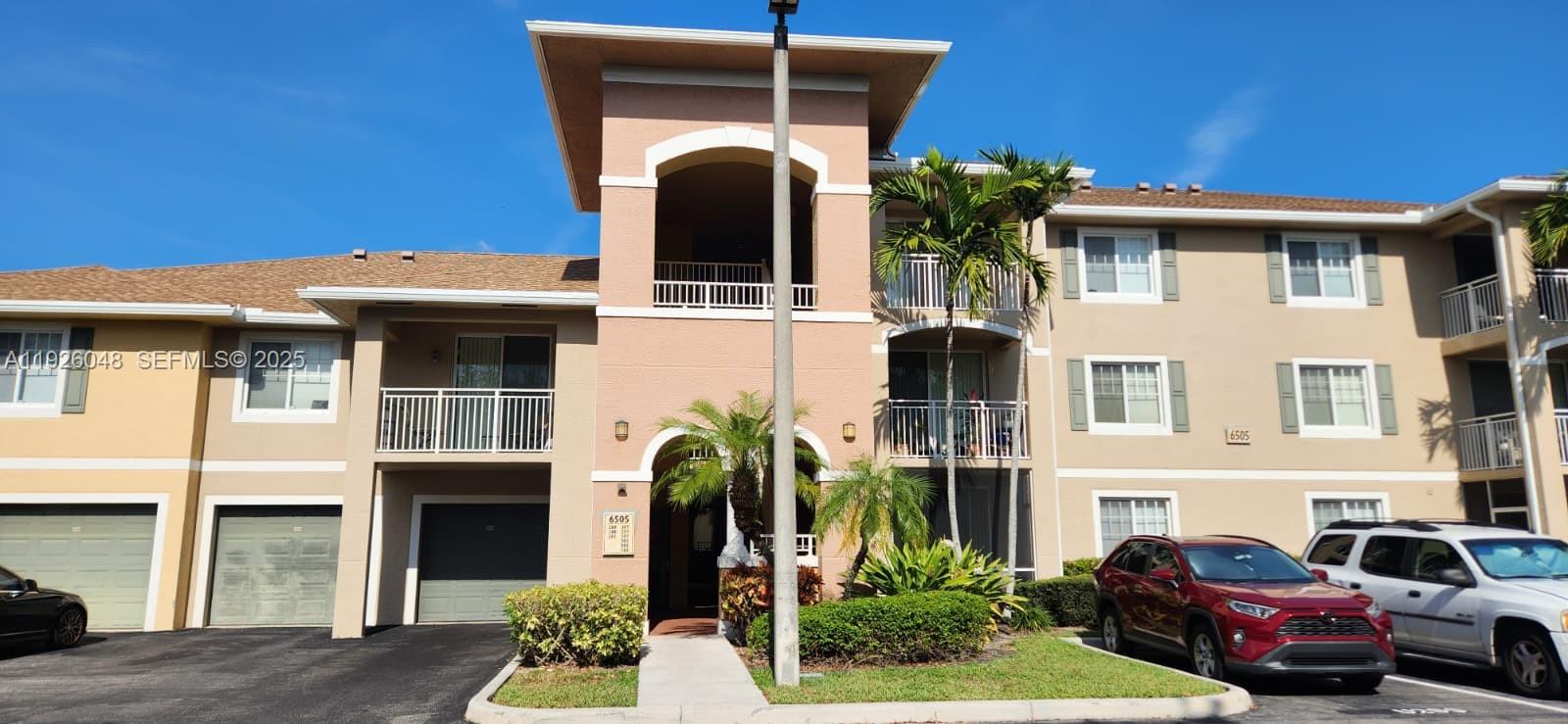 6505 Emerald Dunes Drive, Unit 307 West Palm Beach, FL 33411 - Photo 16 of 17 a front view of a house with garden