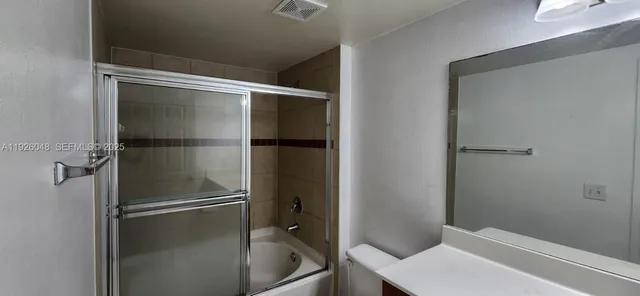 a bathroom with a glass shower door