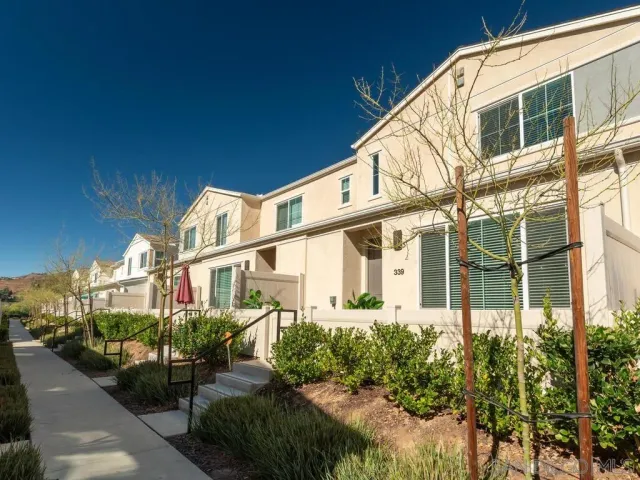 a view of a large white building next to a yard