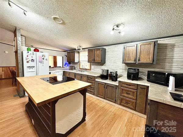 a kitchen with stainless steel appliances granite countertop a sink dishwasher stove refrigerator and cabinets