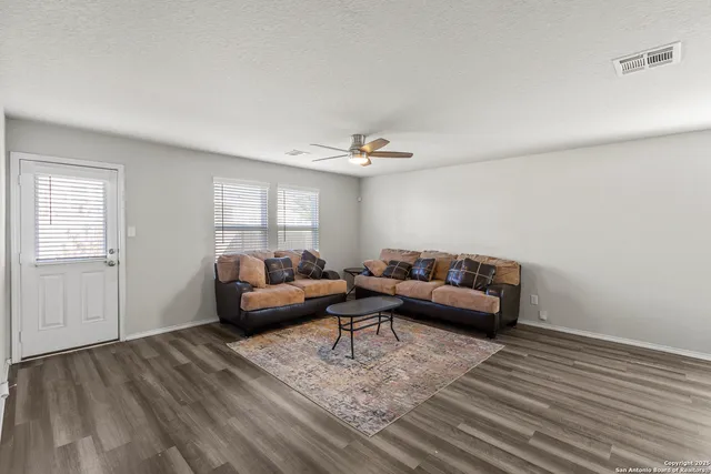 a living room with furniture and a wooden floor