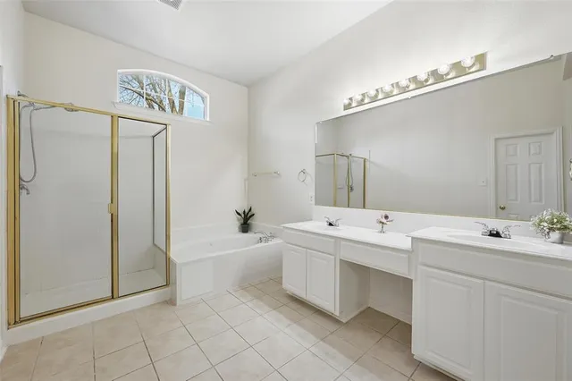 a spacious bathroom with a double vanity sink mirror and bathtub