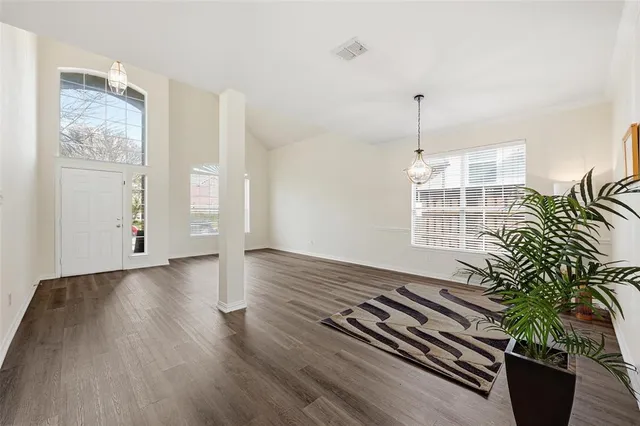 a view of a room with wooden floor and potted plant