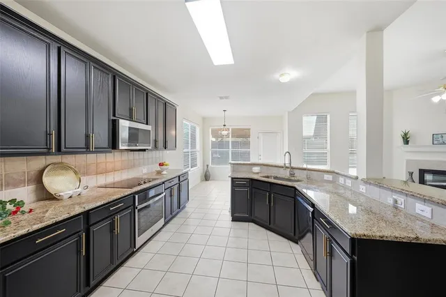 a large kitchen with granite countertop a sink and cabinets