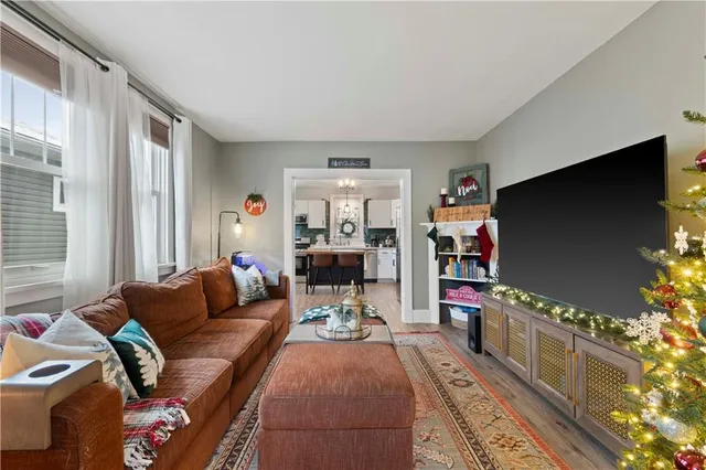 a kitchen with a refrigerator a sink dishwasher a dining table and chairs with wooden floor