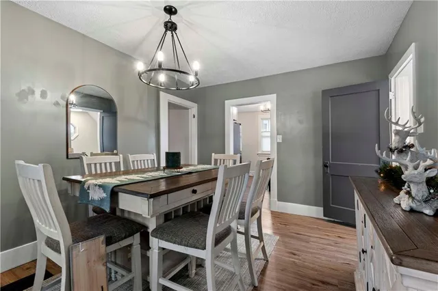 a view of a dining room with furniture a chandelier and wooden floor