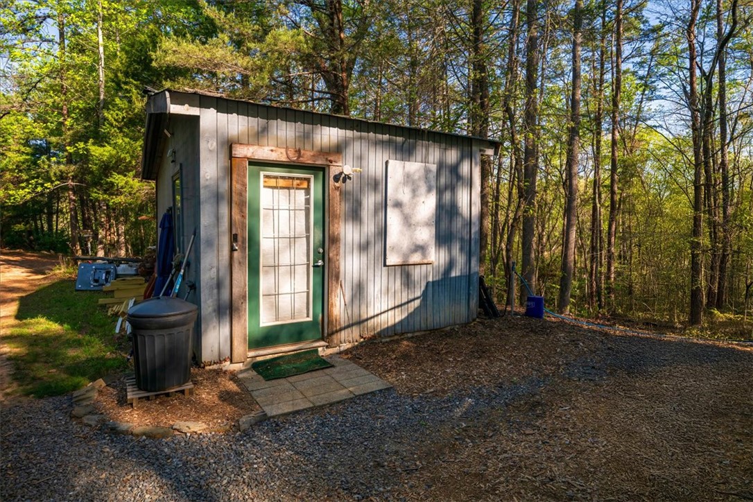 930 Nimmons Bridge Road Salem, SC 29676 - Photo 5 of 19 This charming shed offers a functional space nestled amongst lush trees, providing convenience and utility.